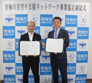 青梅市見守り支援ネットワーク事業協定締結式における大勢待市長と増渕支店長の記念写真