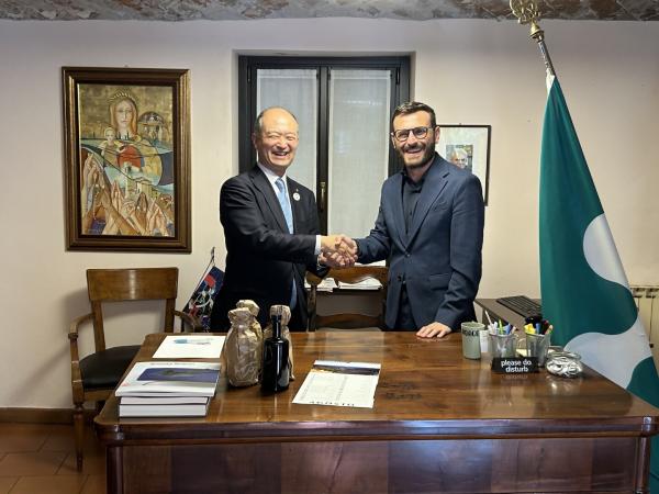 式典で握手をする両市長の写真