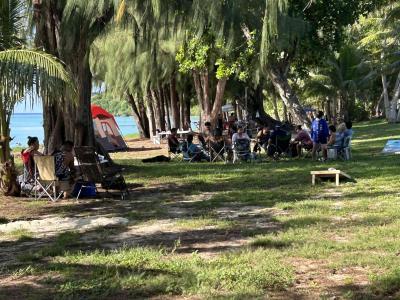 海辺の公園でバーベキューを楽しむ方々の写真